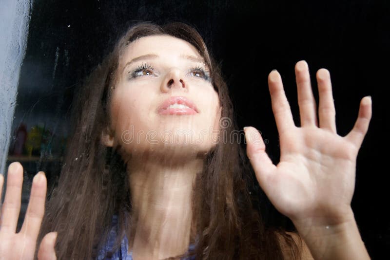 Girl behind wet window