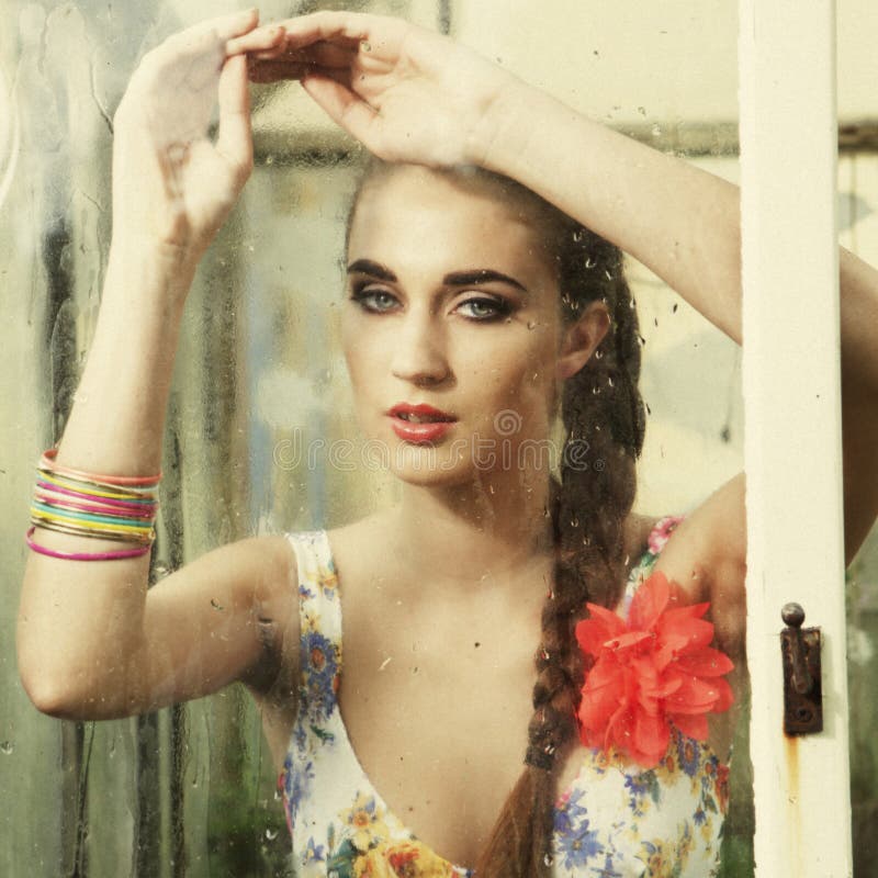 Girl behind wet window