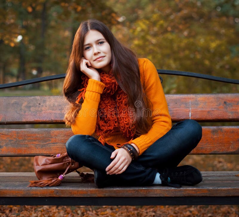 Girl on bench in autumn park