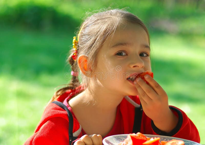 Girl bites tomato