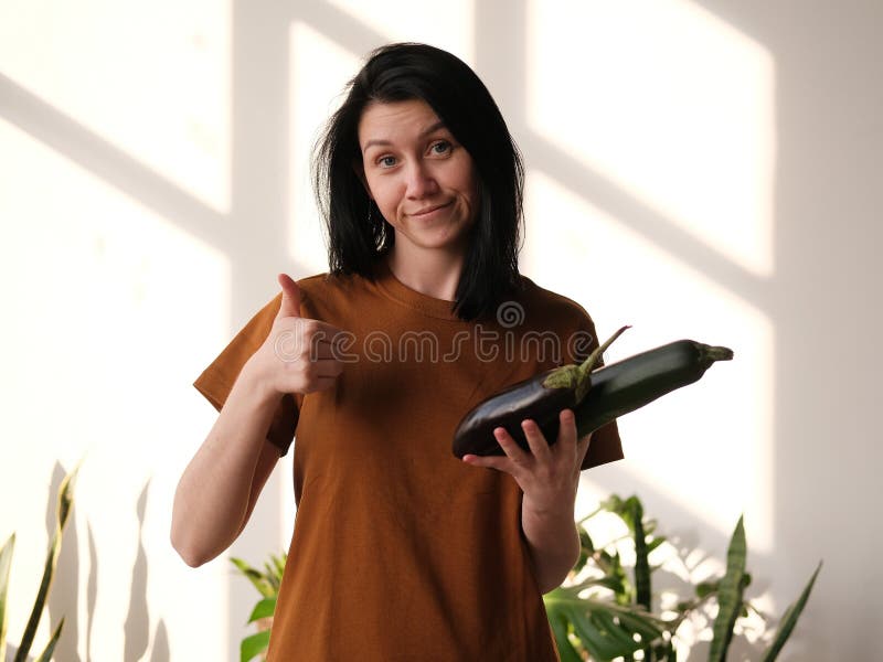 A Girl with Black Hair Lifts a Thumbs Up and Chooses a Healthy Diet. Girl  Holds Eggplant and Zucchini in Her Hand. Great Choice. Stock Photo - Image  of food, great: 158997314