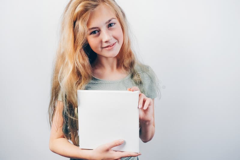 Beautiful teen girl smiling and holding in her hands white empty canvas board. stock images Beautiful teen girl smiling and holding in her hands white empty canvas board. stock images