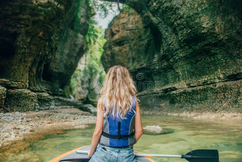 Girl with blond hair in boat on lake in Georgia, nature Martvili Canyon, active leisure for tourists, gorgeous bright