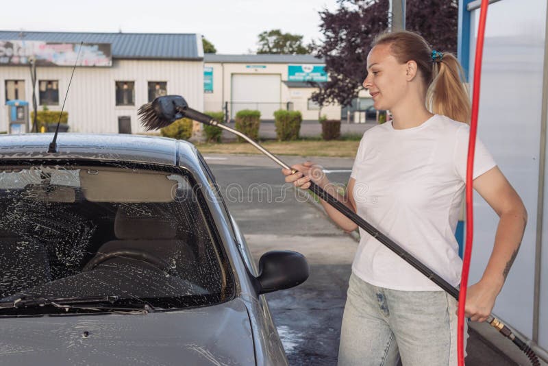 Klassificer rygrad krøllet A Girl with Blond Hair in a White T-shirt and Jeans Washes a Car at a  Self-service Car Wash Stock Image - Image of auto, automobile: 253353247