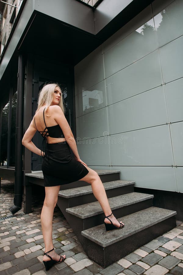 Sexy girl with long legs and short dress posing on stairway Stock