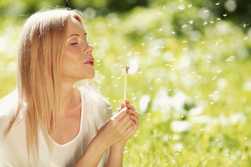 Girl blow on dandelion