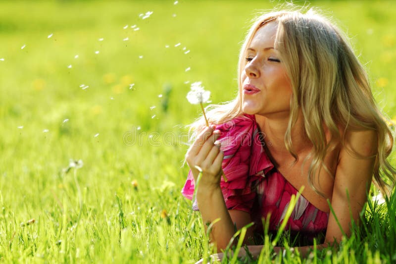 Girl blowing on a dandelion