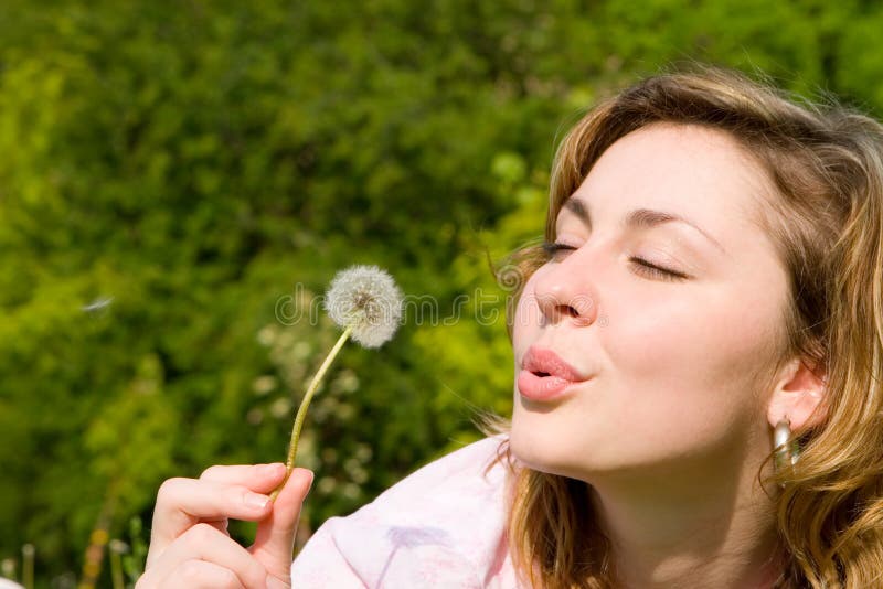 Girl blowing on the dandelion