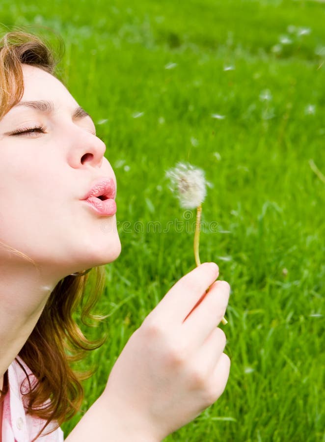 Girl blowing on the dandelion