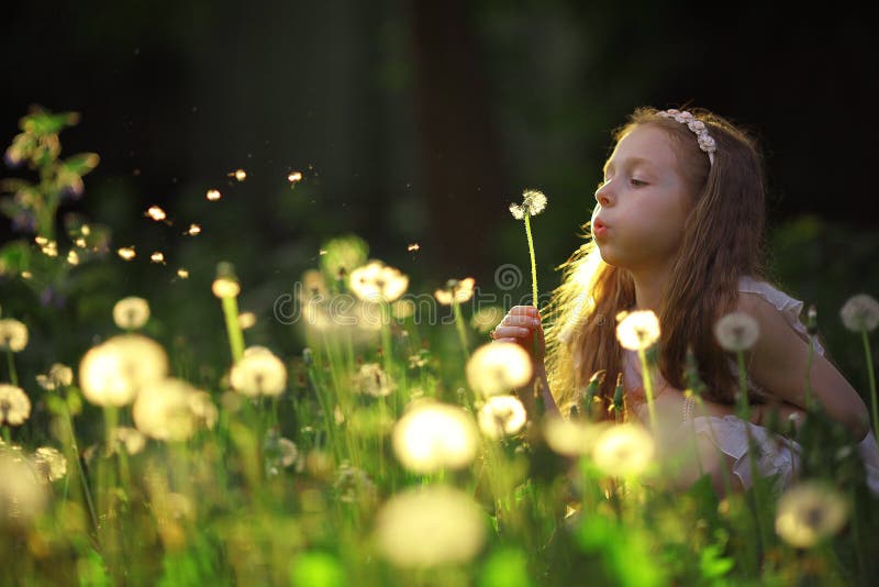 Girl blowing on a dandelion flower