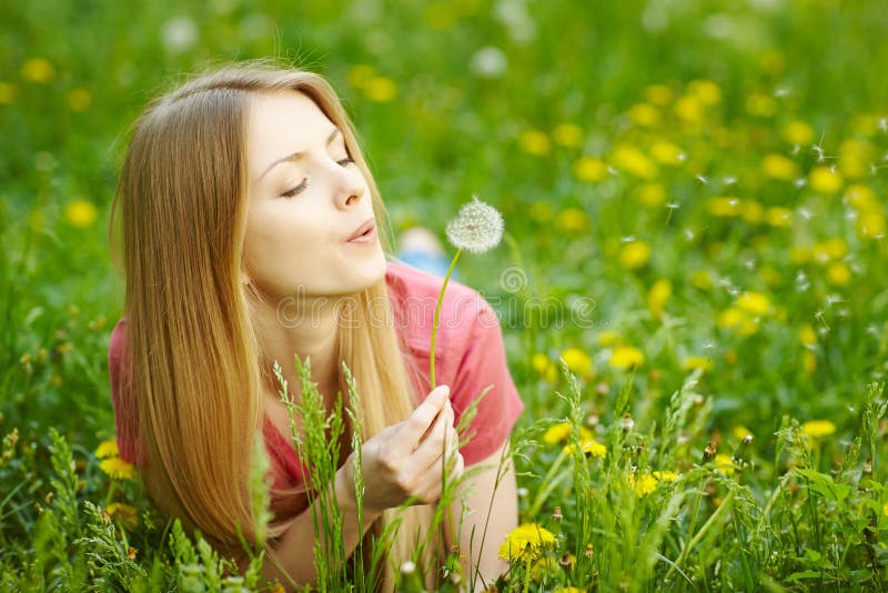 Girl blowing on a dandelion