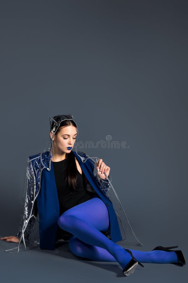 Girl in blue clothes and transparent raincoat lying