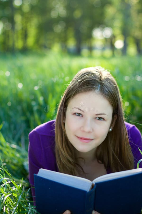 Girl with a book on the grass