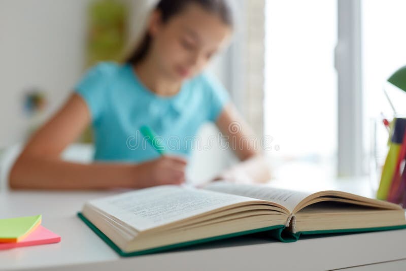 Girl with book writing at home