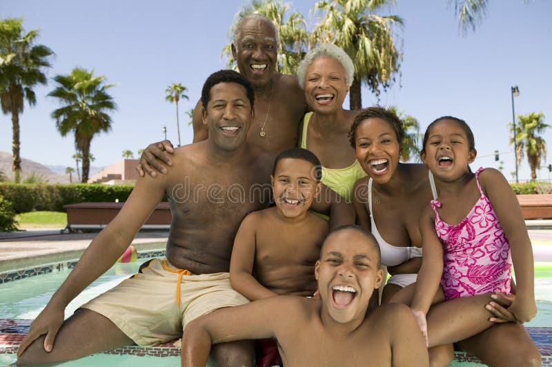 Girl (5-6) boy (7-9) boy (10-12) with parents and grandparents at swimming pool front view portrait.