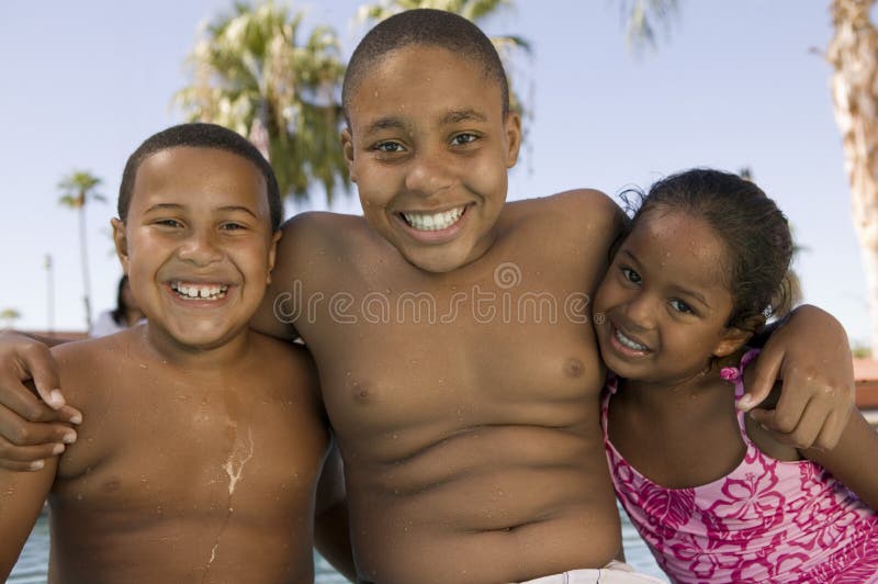 Girl (5-6) boy (7-9) boy (10-12) at swimming pool front view portrait.