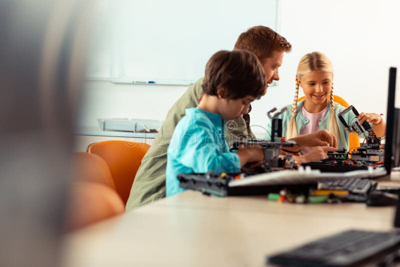 Girl and boy building robots at their science lesson. royalty free stock images