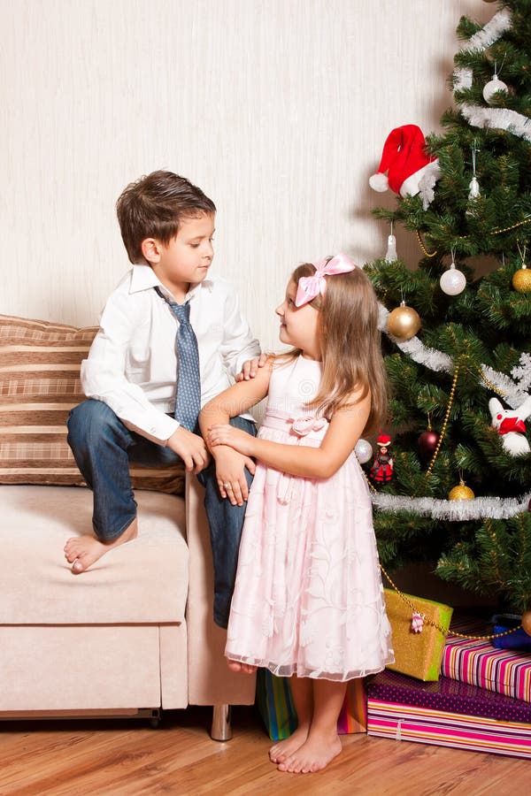 Girl and boy near a fir-tree