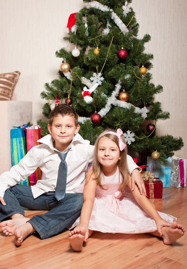 Girl and boy near a fir-tree