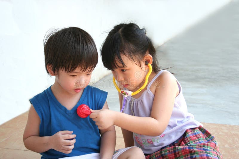 Girl & boy playing with stethoscope