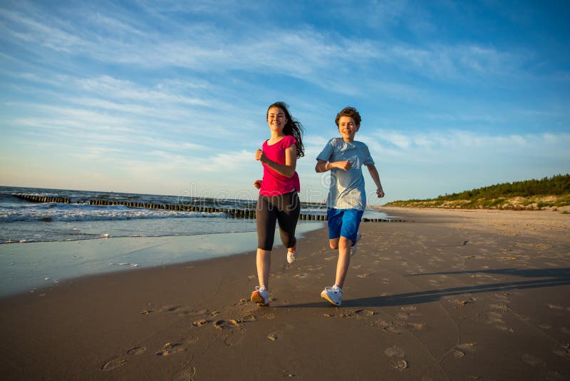 Girl and boy running on beach