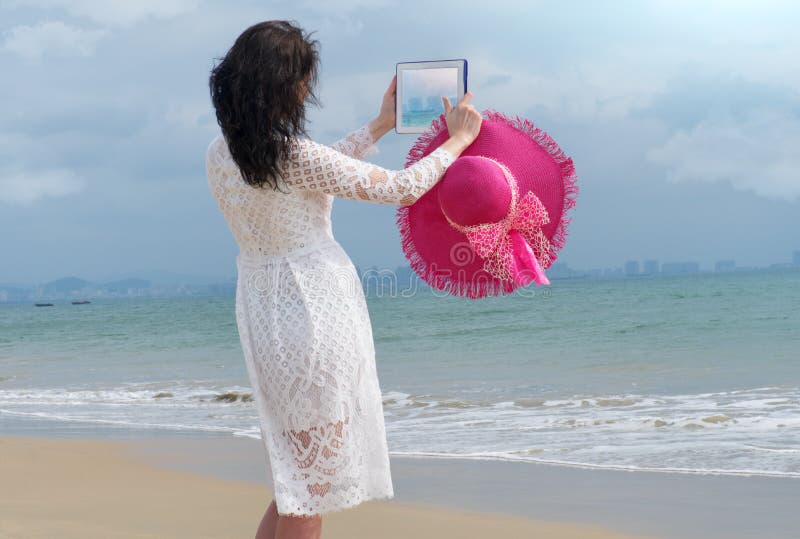 Girl with bright hat and iPad makes the photo stock image Girl with bright hat and iPad makes the photo stock image