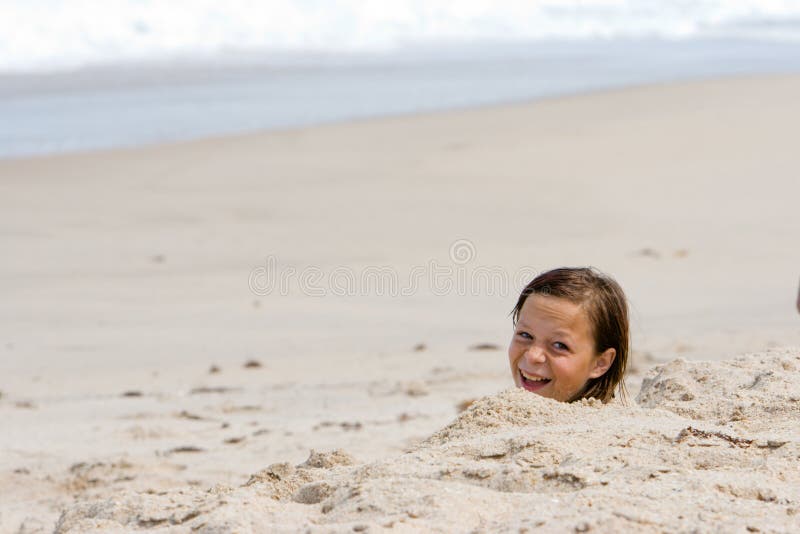 8 Year old girl sitting on beach at dusk Stock Photo