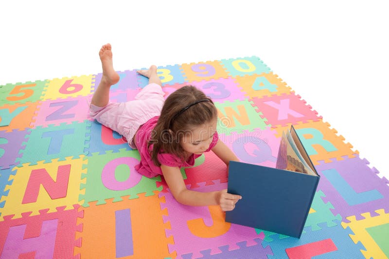 Girl child reading kids book on alphabet mat