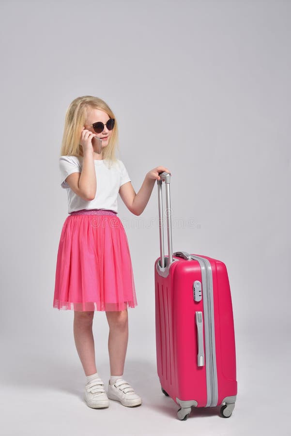 Girl Child Talking on the Phone and Posing with a Pink Suitcase Stock