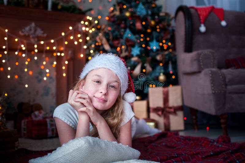 Girl in Christmas Cap Lies on Background of Fireplace and Christmas ...