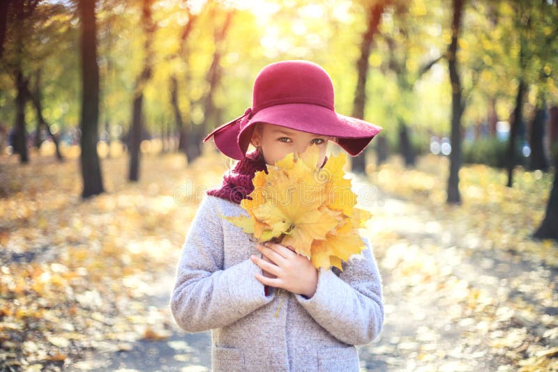 Girl in classic coat and hat in autumn park. Autumn season, fashion, childhood stock images Girl in classic coat and hat in autumn park. Autumn season, fashion, childhood stock images