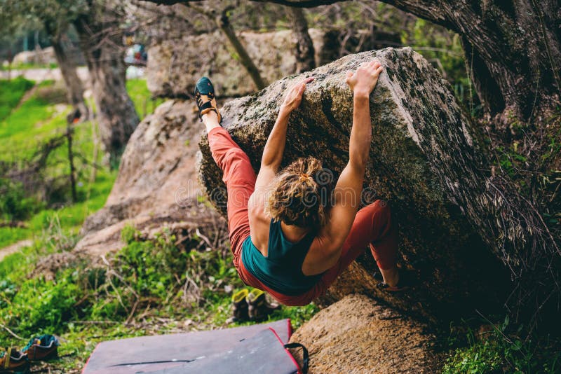Girl climbing hard boulder problem. Sport climbing, bouldering