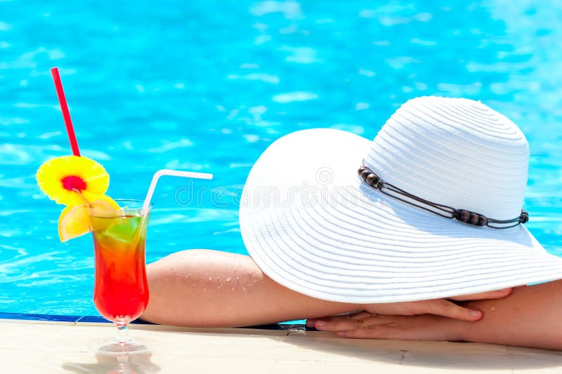 Girl with a cocktail in the pool