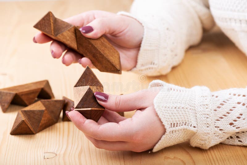 Girl collects puzzle star-shaped dodecahedron. Puzzle concept. Girl collects puzzle star-shaped dodecahedron. Twelve-sided small star-shaped dodecahedron over a stock photography Girl collects puzzle star-shaped dodecahedron. Puzzle concept. Girl collects puzzle star-shaped dodecahedron. Twelve-sided small star-shaped dodecahedron over a stock photography