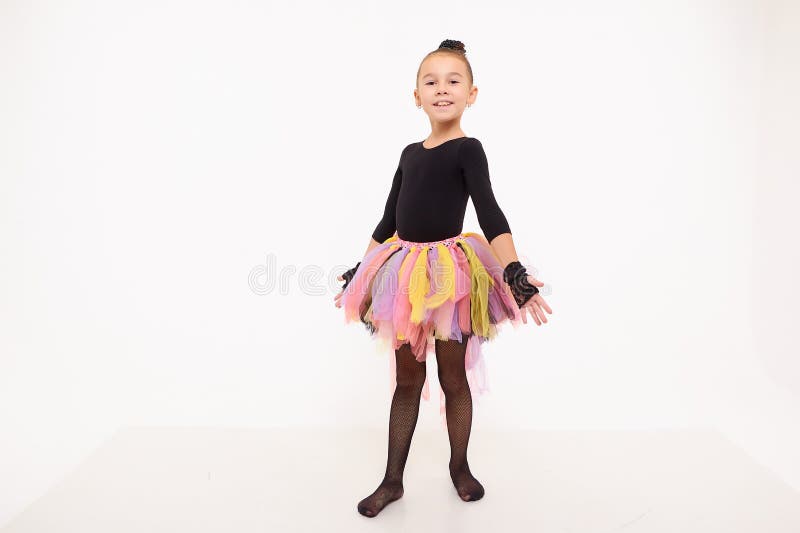 Girl in colorful tutu in the studio with white background during photo shoot. Cute young ballerina inside of the room