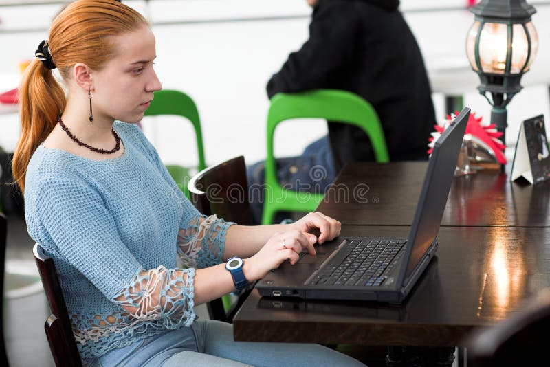 Girl with computer in cafe