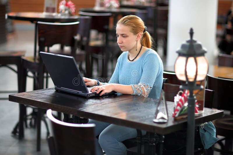 Girl with computer in cafe