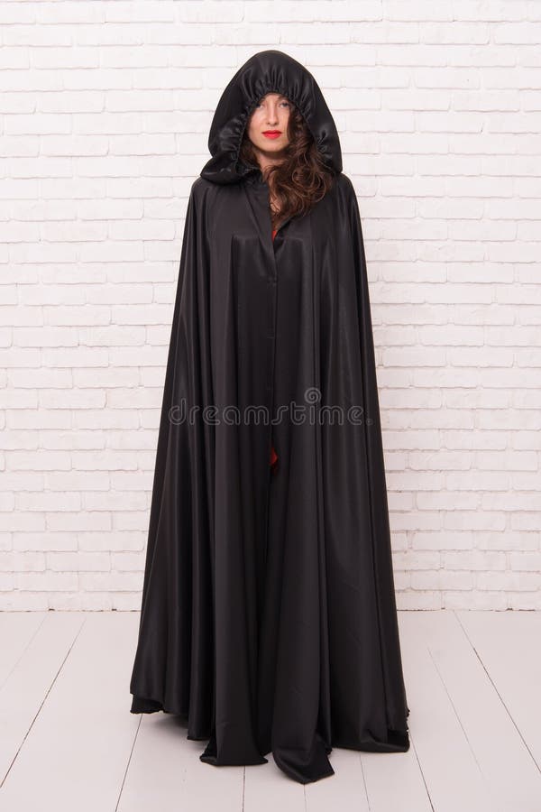 Girl covered with cloak. Devil concept. Halloween masquerade. Halloween party. Damn pretty woman devil. Death in black
