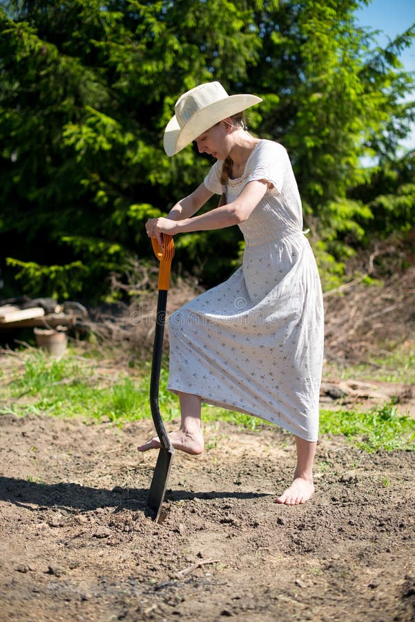 Girl in a cowboy hat with shovel digging hole royalty free stock images