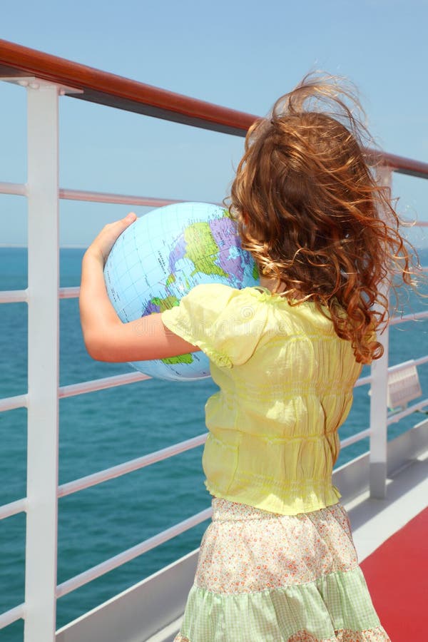 Girl on cruise liner deck and holding globe