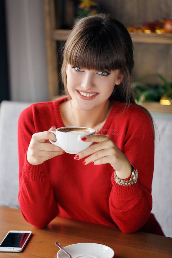 Girl with a Cup of hot tea at a table in a cafe