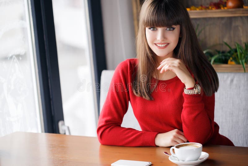 Girl with a Cup of hot tea at a table in a cafe
