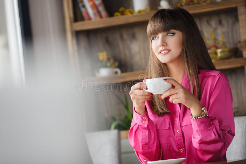 Girl with a Cup of hot tea at a table in a cafe