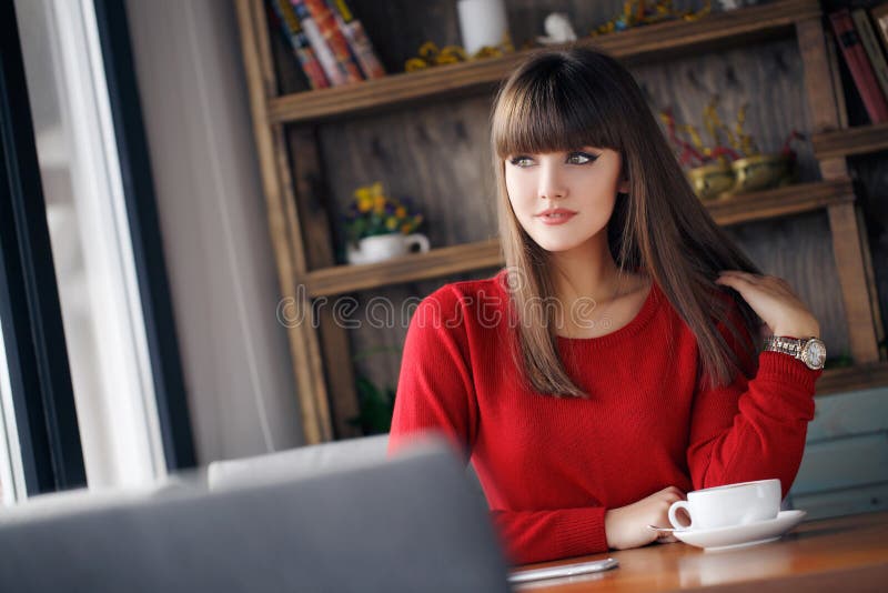 Girl with a Cup of hot tea at a table in a cafe