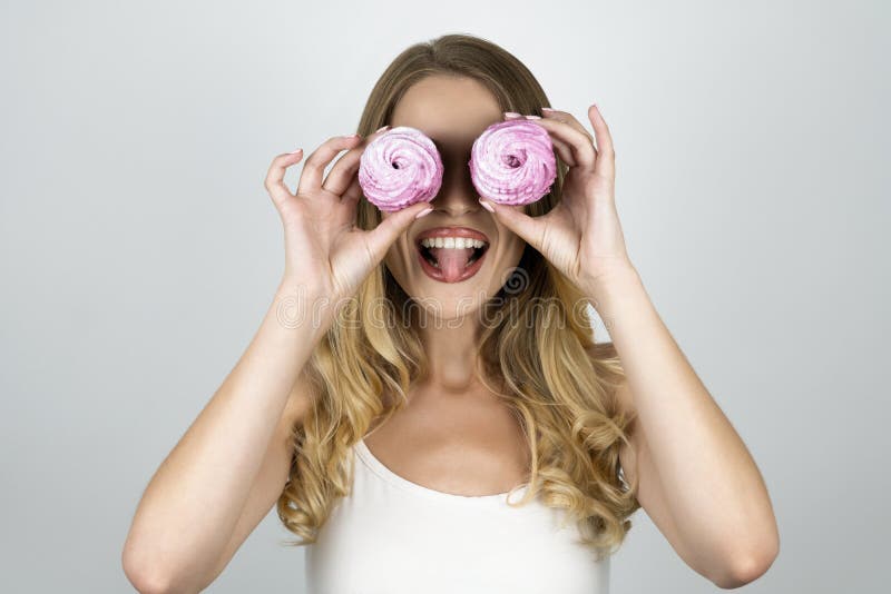 Girl with cupcakes near eyes looks happy isolated white background royalty free stock photography Girl with cupcakes near eyes looks happy isolated white background royalty free stock photography