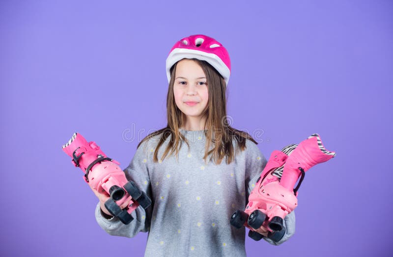 Girl cute teen wear helmet and roller skates on violet background. Active leisure and lifestyle. Roller skating teen stock photos Girl cute teen wear helmet and roller skates on violet background. Active leisure and lifestyle. Roller skating teen stock photos