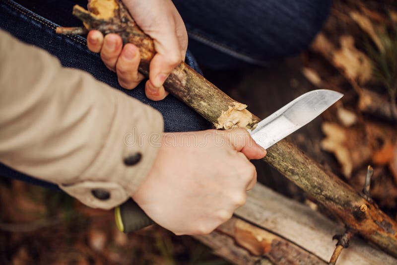 Girl cuts a stick a knife stock photo. Image of knife 53356624