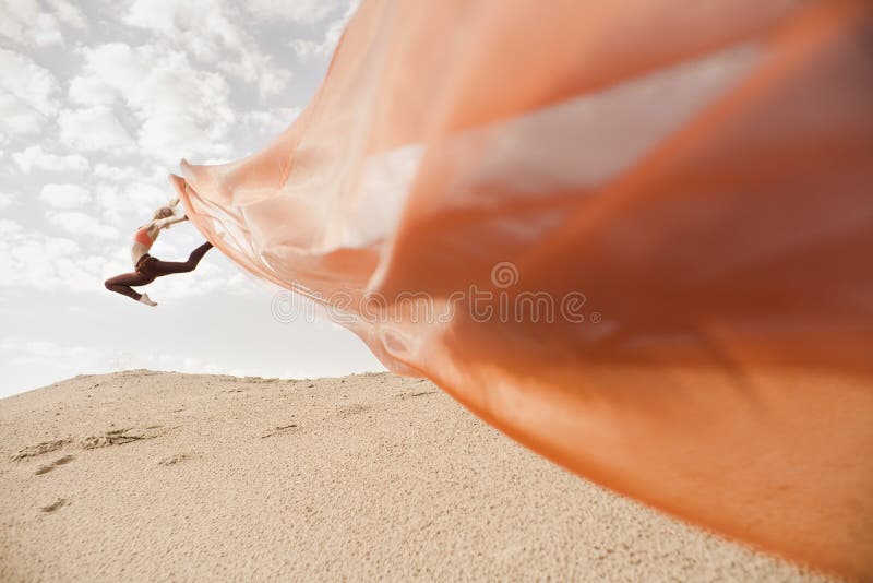 Girl dancing with big orange cloth royalty free stock image