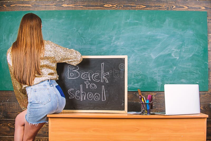 Girl denim skirt breaking school clothing rules. Student teacher mini skirt sexy buttocks sit table blackboard stock photography Girl denim skirt breaking school clothing rules. Student teacher mini skirt sexy buttocks sit table blackboard stock photography