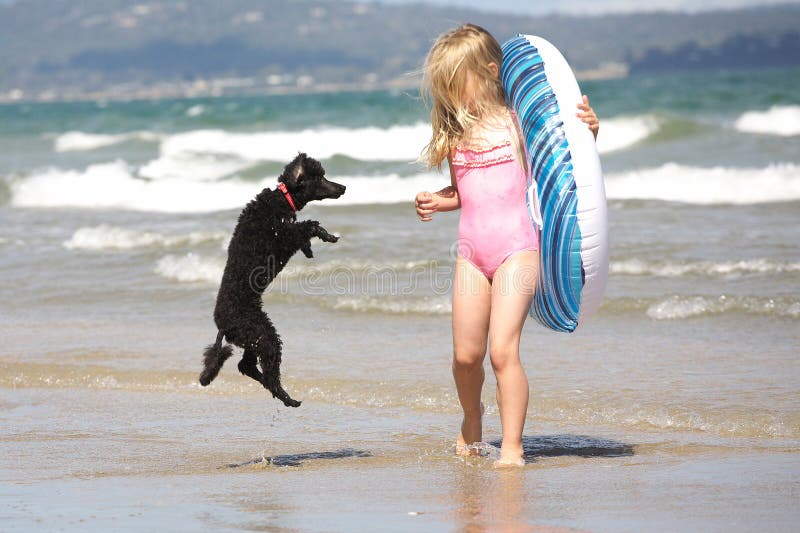 Ragazza e il barboncino divertirsi in spiaggia.